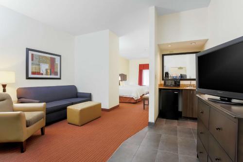 a living room with a couch and a flat screen tv at Hampton Inn Champaign/Urbana in Urbana