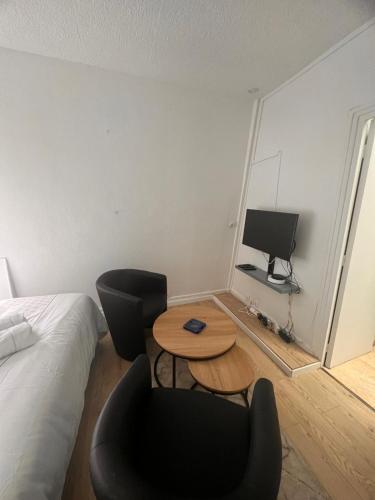 une chambre avec un lit, une table et des chaises dans l'établissement Studio Arc de triomphe - HALA PARIS, à Paris