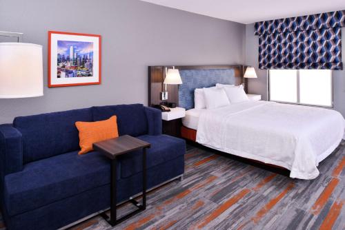 a hotel room with a bed and a couch at Hampton Inn & Suites Legacy Park-Frisco in Frisco