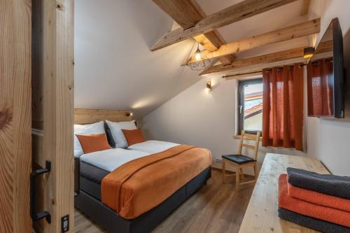 a bedroom with a bed and a chair at Ski-Bike-Apartment Bayerwald in Lohberg