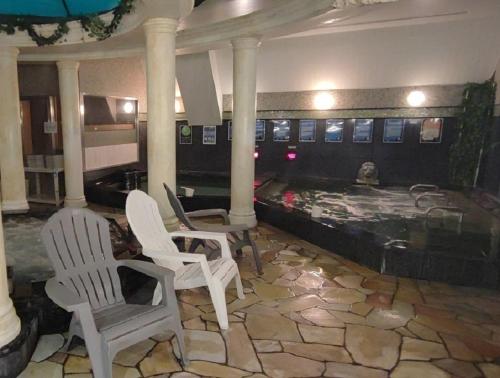 a lobby with white chairs and a table and a pool at The Bed and Spa - Vacation STAY 15993v in Tokorozawa