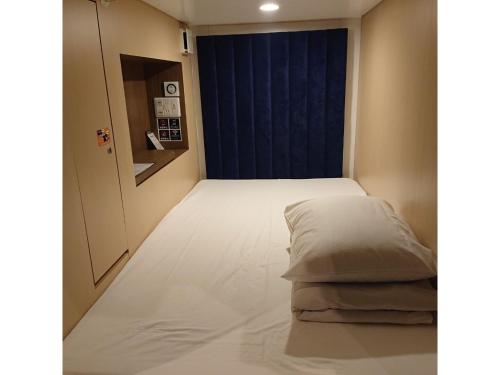 所沢市にあるThe Bed and Spa - Vacation STAY 15993vのベッドと青いドアが備わる小さな部屋です。