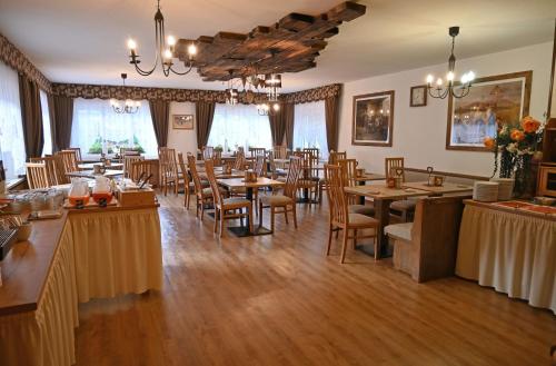 une salle à manger avec des tables et des chaises en bois dans l'établissement Albergo Majorka, à Canazei