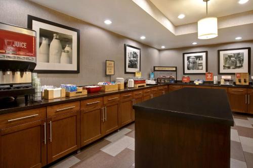 a kitchen with wooden cabinets and a counter top at Hampton Inn Fort Wayne-Southwest in Fort Wayne