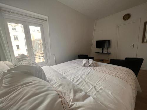 - une chambre avec un lit et 2 chaussons blancs dans l'établissement Studio Arc de triomphe - HALA PARIS, à Paris