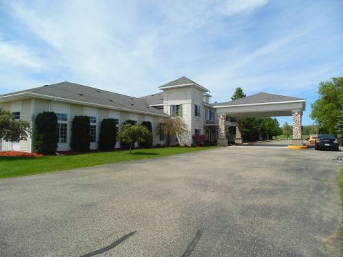 a house with a car parked in the driveway at American Inn and Suites Houghton Lake in Houghton Lake