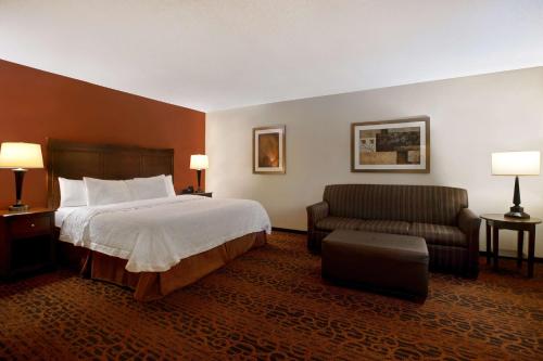 um quarto de hotel com uma cama e um sofá em Hampton Inn Fort Wayne-Southwest em Fort Wayne