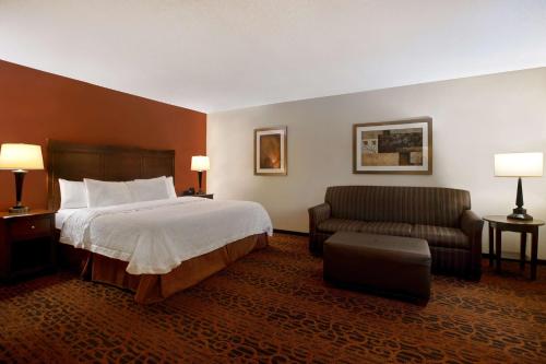 a hotel room with a bed and a couch at Hampton Inn Fort Wayne-Southwest in Fort Wayne