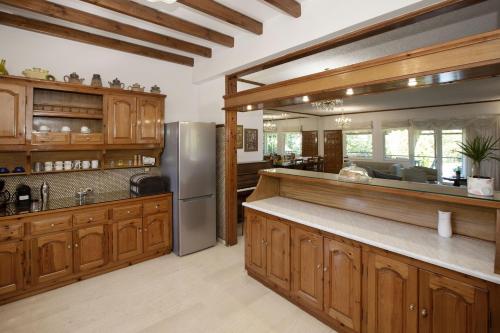 a kitchen with wooden cabinets and a stainless steel refrigerator at KORALIA MARATHON VILLA in Nea Makri