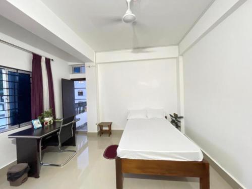 ein Schlafzimmer mit einem Bett und einem Schreibtisch. in der Unterkunft Alub Naam Homestay in Itānagar