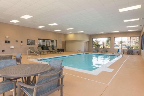 a large pool with a table and chairs and a table and a tablesktop at Hampton Inn East Lansing in East Lansing