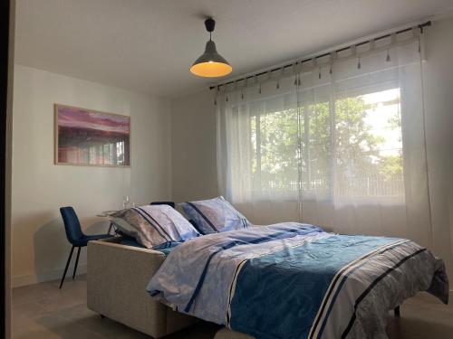 1 dormitorio con cama y ventana en Au calme proche centre-ville, studio rénové avec équipements neufs et parking privé en Gap