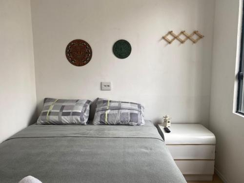 - une chambre avec un lit et un mur blanc dans l'établissement Kambô hostel, à São Paulo