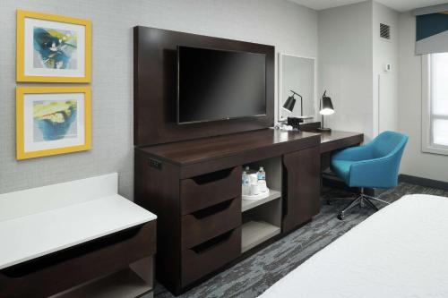 a hotel room with a desk with a television and a chair at Hampton Inn & Suites Memphis-Beale Street in Memphis