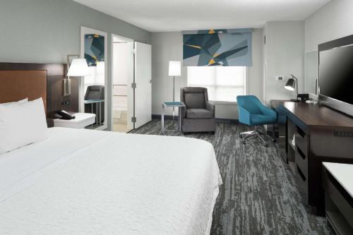 Habitación de hotel con cama grande y escritorio. en Hampton Inn & Suites Memphis-Beale Street, en Memphis