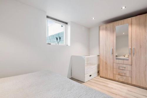 a bedroom with a large bed and a wooden cabinet at Demims Apartments Oslo Airport in Eidsvoll