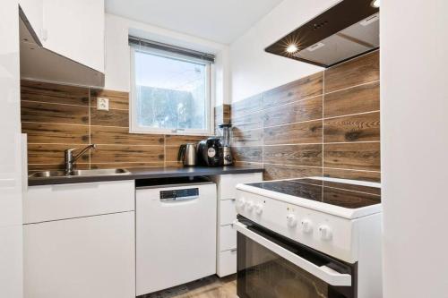 uma cozinha com electrodomésticos brancos e paredes de madeira em Demims Apartments Oslo Airport em Eidsvoll