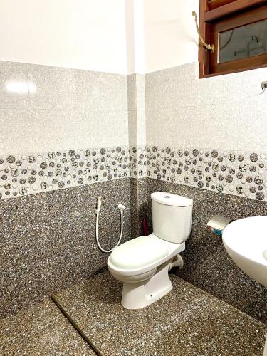 a bathroom with a toilet and a sink at Shan Star Weligama in Weligama