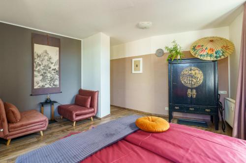 a bedroom with a large bed and two chairs at Kerkermeister Pension in Auerbach