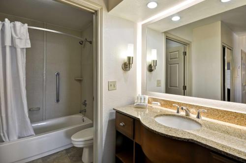 a bathroom with a sink and a toilet and a mirror at Homewood Suites by Hilton Phoenix-Biltmore in Phoenix