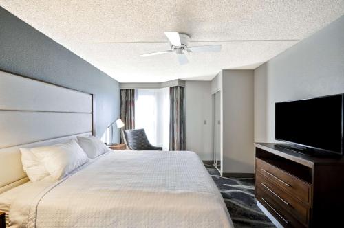 a hotel room with a bed and a flat screen tv at Homewood Suites by Hilton Phoenix-Biltmore in Phoenix