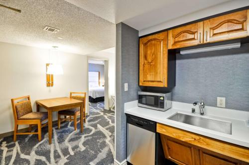 eine Küche mit einem Waschbecken und einem Tisch in einem Zimmer in der Unterkunft Homewood Suites by Hilton Phoenix-Biltmore in Phoenix