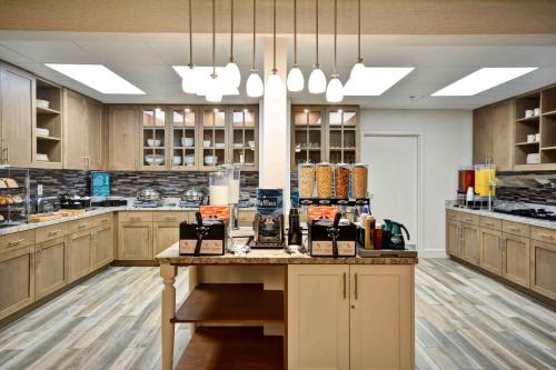 a large kitchen with wooden cabinets and a table with food at Homewood Suites by Hilton San Antonio Northwest in San Antonio