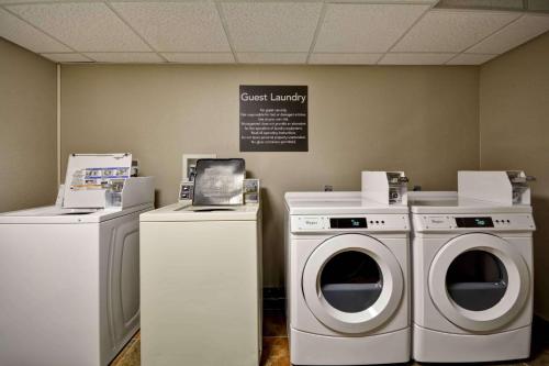 a laundry room with two machines and a sign on the wall at Homewood Suites by Hilton San Antonio Northwest in San Antonio