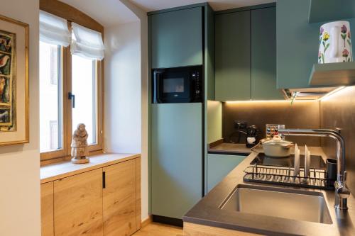 a kitchen with a sink and a refrigerator at Maison Luboz - Courmayeur in Courmayeur