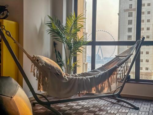 a hammock in a room with a large window at The Female Journey Hostel - JBR in Dubai