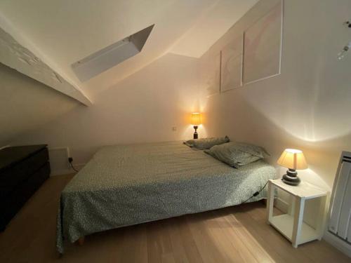 - une chambre avec un lit et deux lampes sur une table dans l'établissement Cosy Duplex Centre Trouville parking gratuit, à Trouville-sur-Mer
