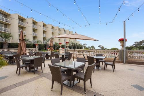 a patio with tables and chairs and an umbrella at Hilton La Jolla Torrey Pines in San Diego