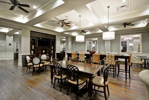 a dining room and living room with a table and chairs at Hampton Inn & Suites Savannah Historic District in Savannah