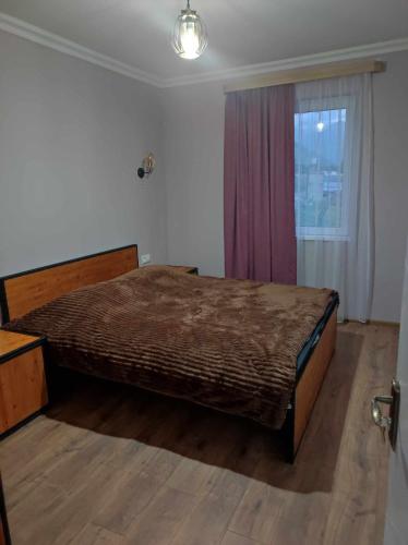 a bedroom with a bed and a window at COZY house მყუდრო სახლი in Kazbegi