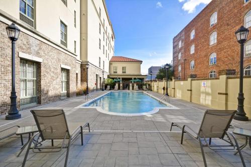 a swimming pool in a courtyard between two buildings at Hampton Inn & Suites Savannah Historic District in Savannah