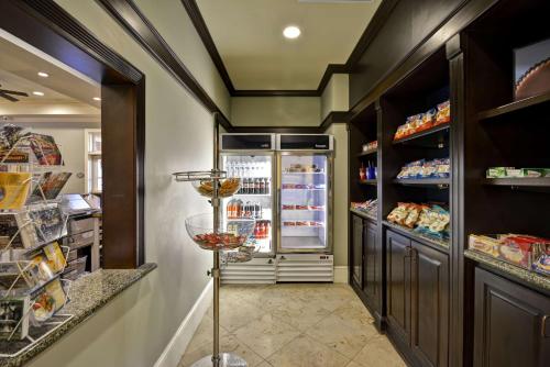 a kitchen with a refrigerator and shelves at Hampton Inn & Suites Savannah Historic District in Savannah