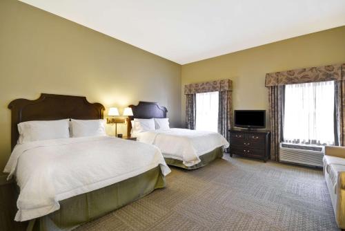 a hotel room with two beds and a flat screen tv at Hampton Inn & Suites Savannah Historic District in Savannah