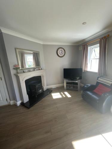 a living room with a fireplace and a couch at Faithlegg Estate, Mews Holiday Home, Waterford in Waterford