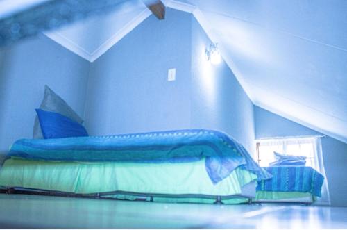 ein blaues Schlafzimmer mit einem Bett mit einer blauen Bettdecke in der Unterkunft 19 @ Pendleberry in Bela-Bela
