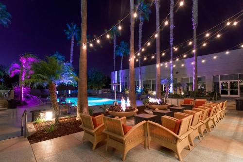 um pátio com mesas e cadeiras e uma piscina à noite em DoubleTree by Hilton San Diego-Mission Valley em San Diego