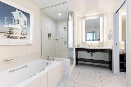 a white bathroom with a tub and a sink at DoubleTree by Hilton San Diego-Mission Valley in San Diego