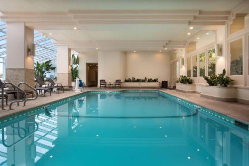 a swimming pool with blue water in a building at Embassy Suites by Hilton San Francisco Airport Oyster Point in South San Francisco