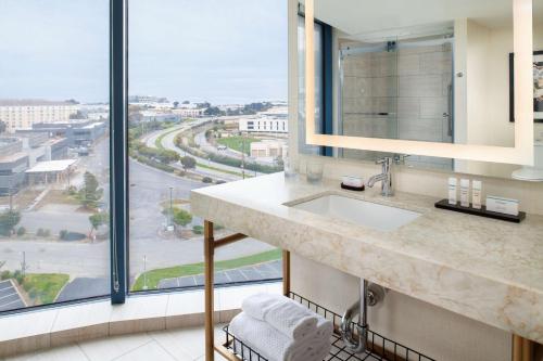 a bathroom with a sink and a large window at Embassy Suites San Francisco Airport - South San Francisco in South San Francisco