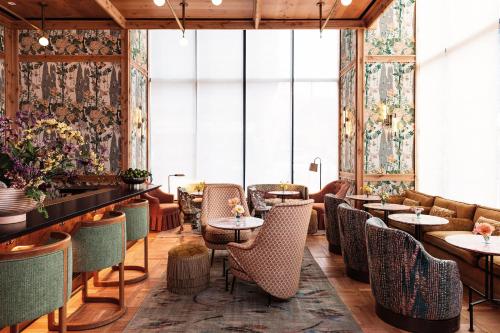 a restaurant with tables and chairs and windows at Austin Proper Hotel, a Member of Design Hotels in Austin