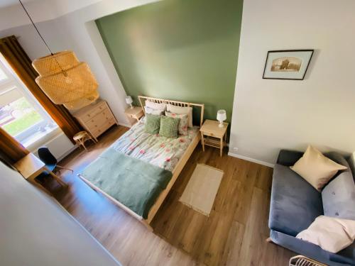 einen Blick über ein Schlafzimmer mit einem Bett und einem Sofa in der Unterkunft Apartament Pod Lipami in Olsztyn