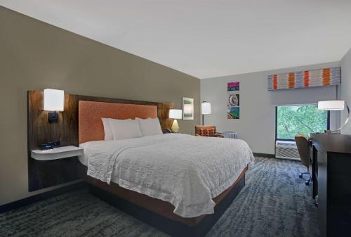 a hotel room with a large bed and a desk at Hampton Inn Salisbury in Salisbury