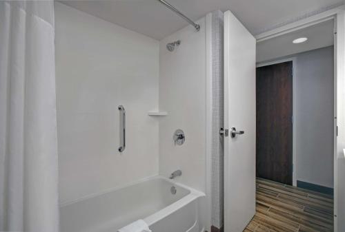a white bathroom with a tub and a shower at Hampton Inn Salisbury in Salisbury