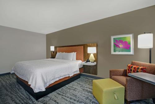 a hotel room with a bed and a chair at Hampton Inn Salisbury in Salisbury