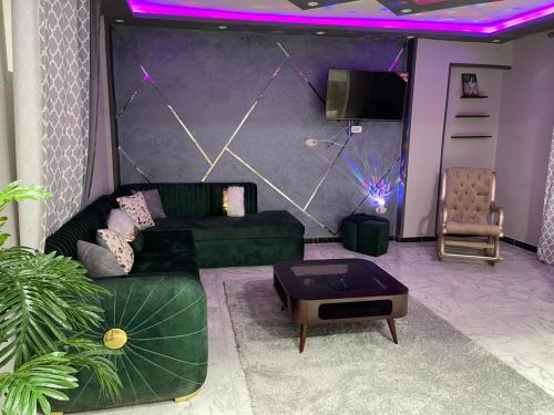 sala de estar con sofá verde e iluminación púrpura en سيدي بشر بحري امام بير مسعود, en Alejandría