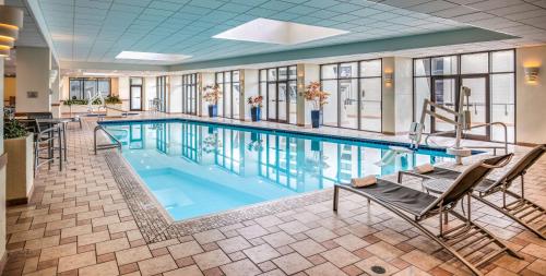 a pool in a hotel with chairs at Hilton Salt Lake City Center in Salt Lake City